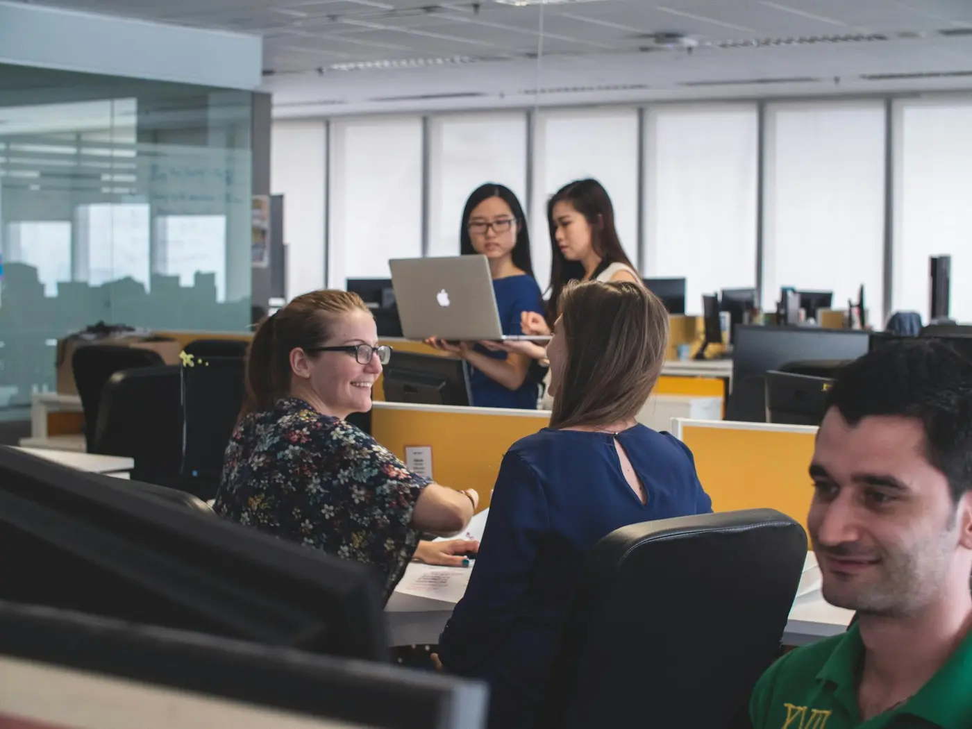 Team members collaborating around a computer