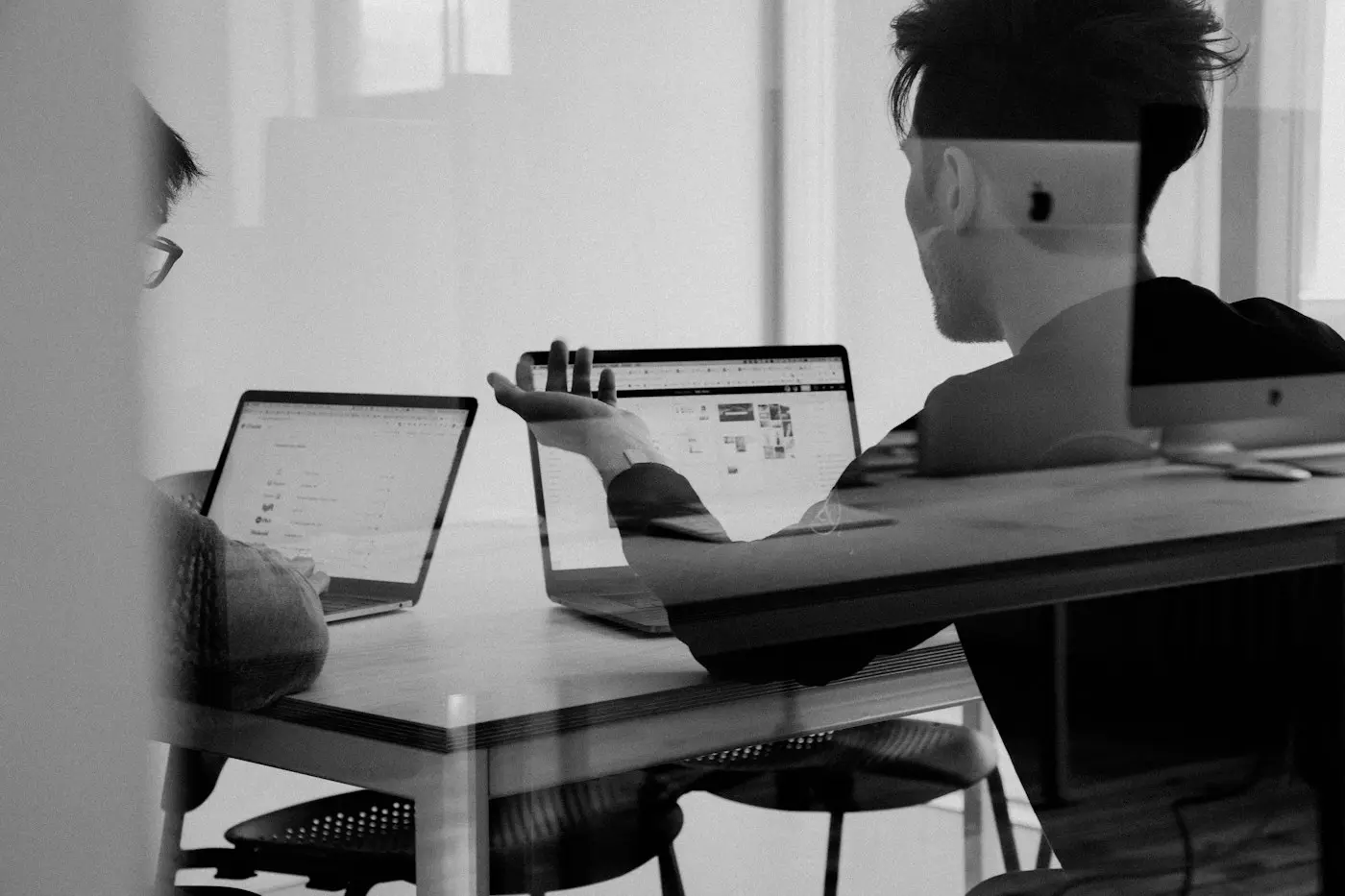 Colleagues carefully discussing a laptop screen